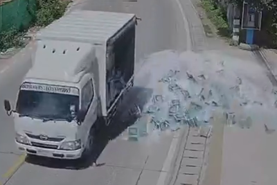 [Video] Xe tải vào cua đánh rơi hàng trăm chai bia xuống đường