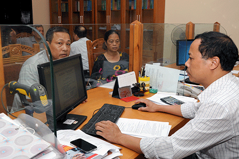 Cán bộ tại bộ phận một cửa Chi cục Thuế Vĩnh Yên (Vĩnh Phúc) hướng dẫn người nộp thuế làm thủ tục. Nguồn: internet