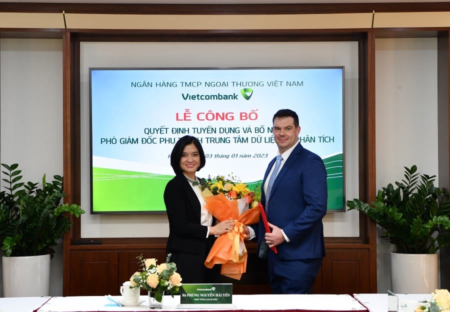 Bà Phùng Nguyễn Hải Yến - Phó Tổng giám đốc Vietcombank trao Quyết định và tặng hoa chúc mừng ông Michel Edward Pearmain