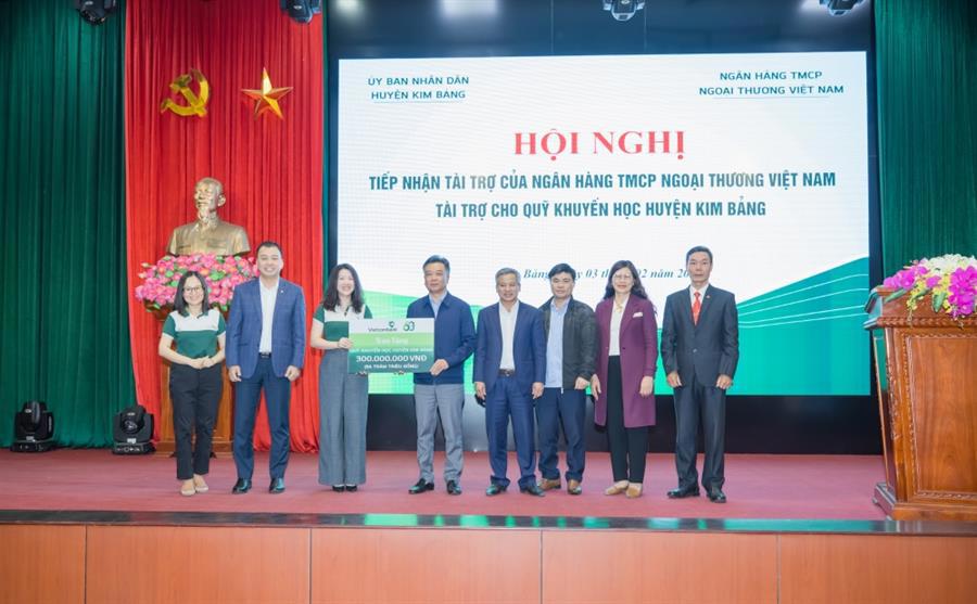 Đại diện Vietcombank, bà Phan Khánh Ngọc - Giám đốc Trung tâm hỗ trợ khách hàng (thứ 3 từ trái sang) trao bảng tượng trưng số tiền hỗ trợ tặng Quỹ khuyến học huyện Kim Bảng