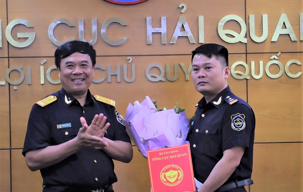Phó Tổng cục trưởng Nguyễn Văn Thọ trao quyết định và tặng hoa chúc mừng tân Phó Chánh Văn phòng Tổng cục Hải quan Nguyễn Thành Sơn. 