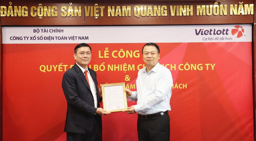 Thứ trưởng Bộ Tài chính Nguyễn Đức Chi (bên phải) trao quyết định bổ nhiệm Chủ tịch Công ty Xổ số Điện toán Việt Nam cho ông Nguyễn Thanh Đạm.