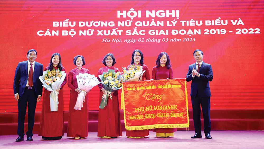 Đảng ủy, Hội đồng thành viên, Ban điều hành Agribank trao tặng nữ đoàn viên, người lao động bức trướng với 8 chữ vàng: Năng động – Sáng tạo – Nhân hậu – Đảm đang. Nguồn: Agribank.