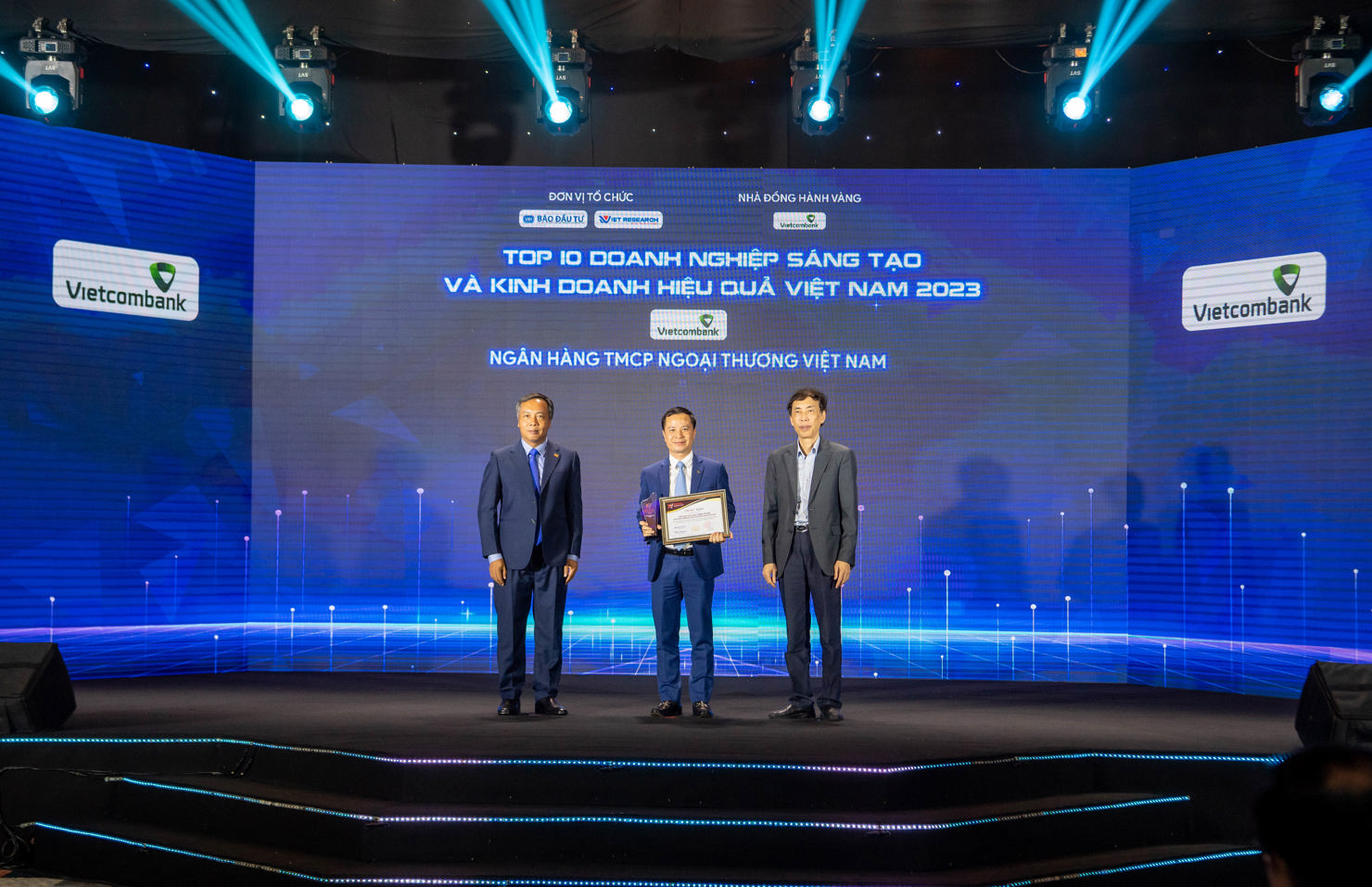 Ông Lê Hoàng Tùng - Kế toán trưởng (đứng giữa) thay mặt Lãnh đạo Vietcombank nhận chứng nhận vinh danh Vietcombank dẫn đầu Top 10 ngân hàng sáng tạo và kinh doanh hiệu quả năm 2023.