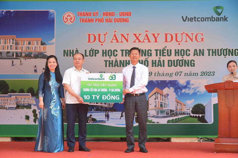 Ông Nguyễn Xuân Cao Cường - Giám đốc Vietcombank Hải Dương trao biển tượng trưng tài trợ kinh phí xây dựng trường cho đại diện lãnh đạo UBND thành phố và hiệu trưởng trường tiểu học An Thượng