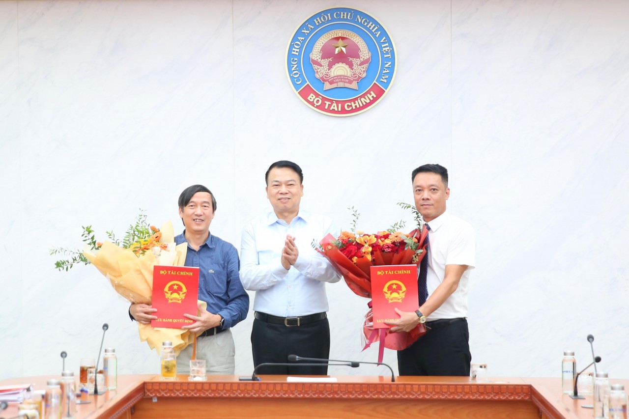 Thứ trưởng Bộ Tài chính Nguyễn Đức Chi trao quyết định nghỉ hưu cho ông Nguyễn Đại Trí (bên trái) và quyết định bổ nhiệm cho ông Nguyễn Việt Hà (bên phải).