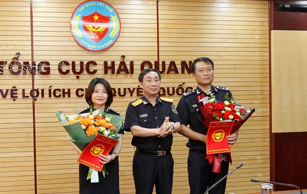Phó Tổng cục trưởng Tổng cục Hải quan Hoàng Việt Cường trao định bổ nhiệm và tặng hoa chúc mừng 2 tân Phó Cục trưởng Cục Quản lý rủi ro. Ảnh: Q.H