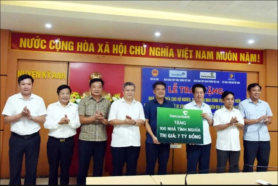 Ông Nguyễn Mỹ Hào - Thành viên HĐQT Vietcombank (thứ 3, từ phải sang) trao biểu trưng hỗ trợ kinh phí xây dựng 100 căn nhà tình nghĩa tổng trị giá 7 tỷ đồng