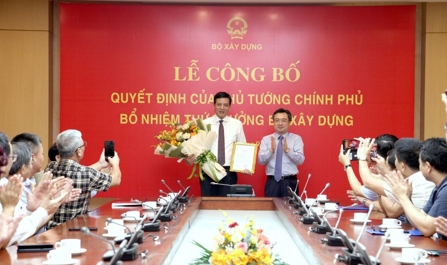 Bộ trưởng Bộ Xây dựng Nguyễn Thanh Nghị trao Quyết định, tặng hoa chúc mừng tân Thứ trưởng Bùi Xuân Dũng.