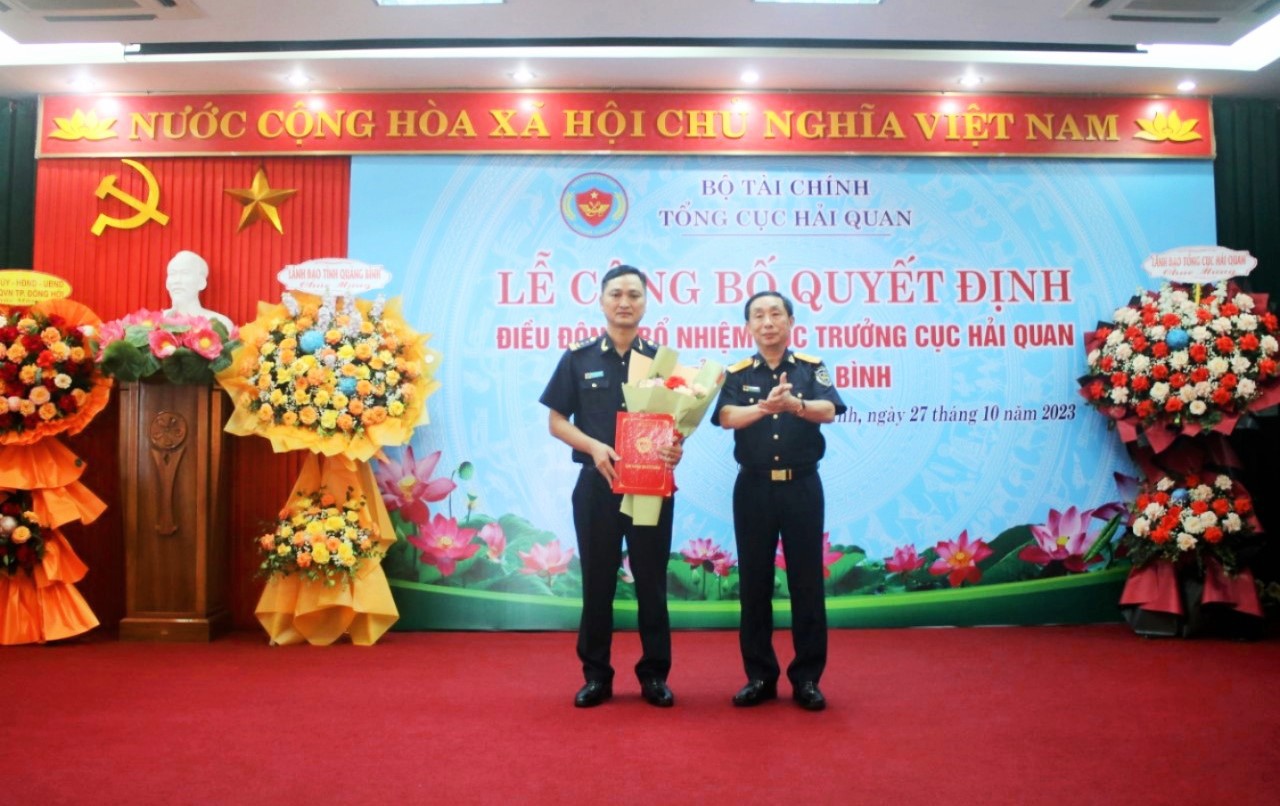 Phó Tổng cục trưởng Tổng cục Hải quan Hoàng Việt Cường trao quyết định bổ nhiệm và tặng hoa chúc mừng tân Cục trưởng Cục Hải quan Quảng Bình.