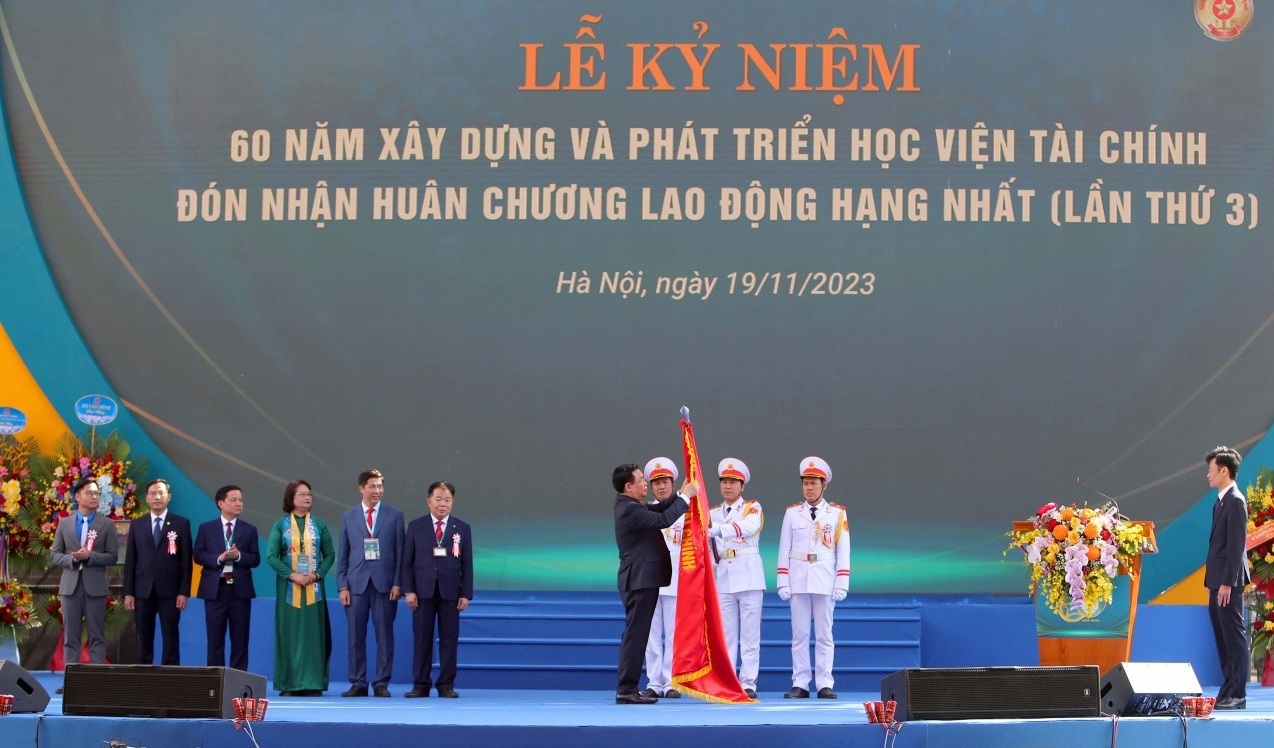 Chủ tịch Quốc hội Vương Đình Huệ gắn Huân chương Lao động hạng Nhất (lần thứ 3) lên lá cờ truyền thống của Học viện tài chính