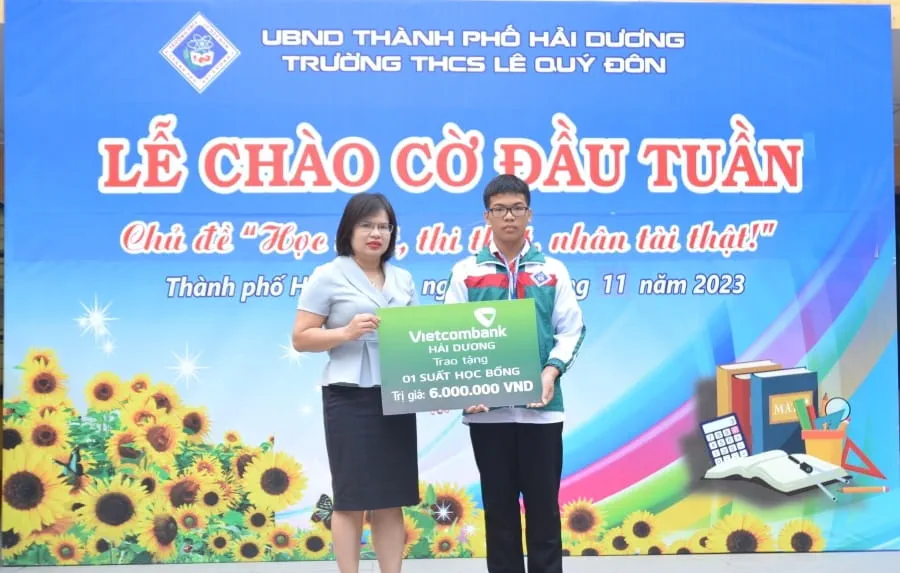 Bà Hoàng Thị Kim Ngân - Chủ tịch Công đoàn cơ sở, Phó Giám đốc Vietcombank Hải Dương trao học bổng cho em Ngô Gia Huy - lớp 7C trường THCS Lê Quý Đôn