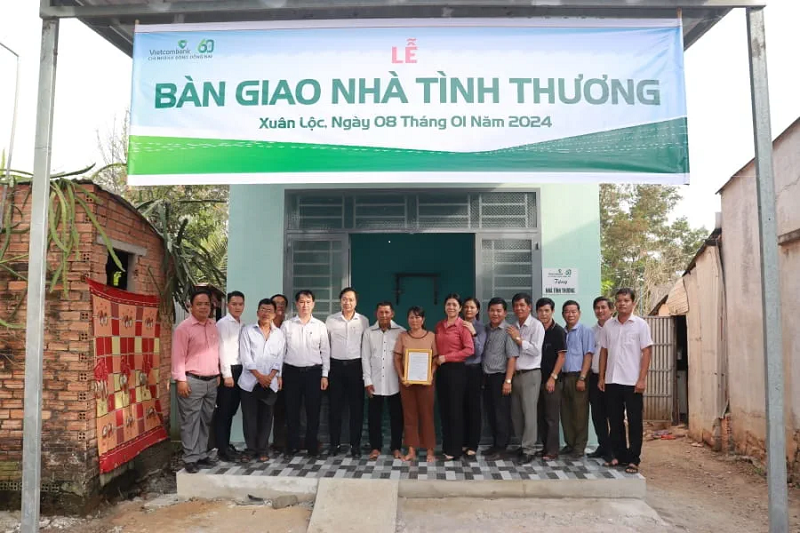 Đại diện Vietcombank Đông Đồng Nai và chính quyền địa phương chụp ảnh lưu niệm cùng gia đình tại lễ trao tặng nhà tình thương