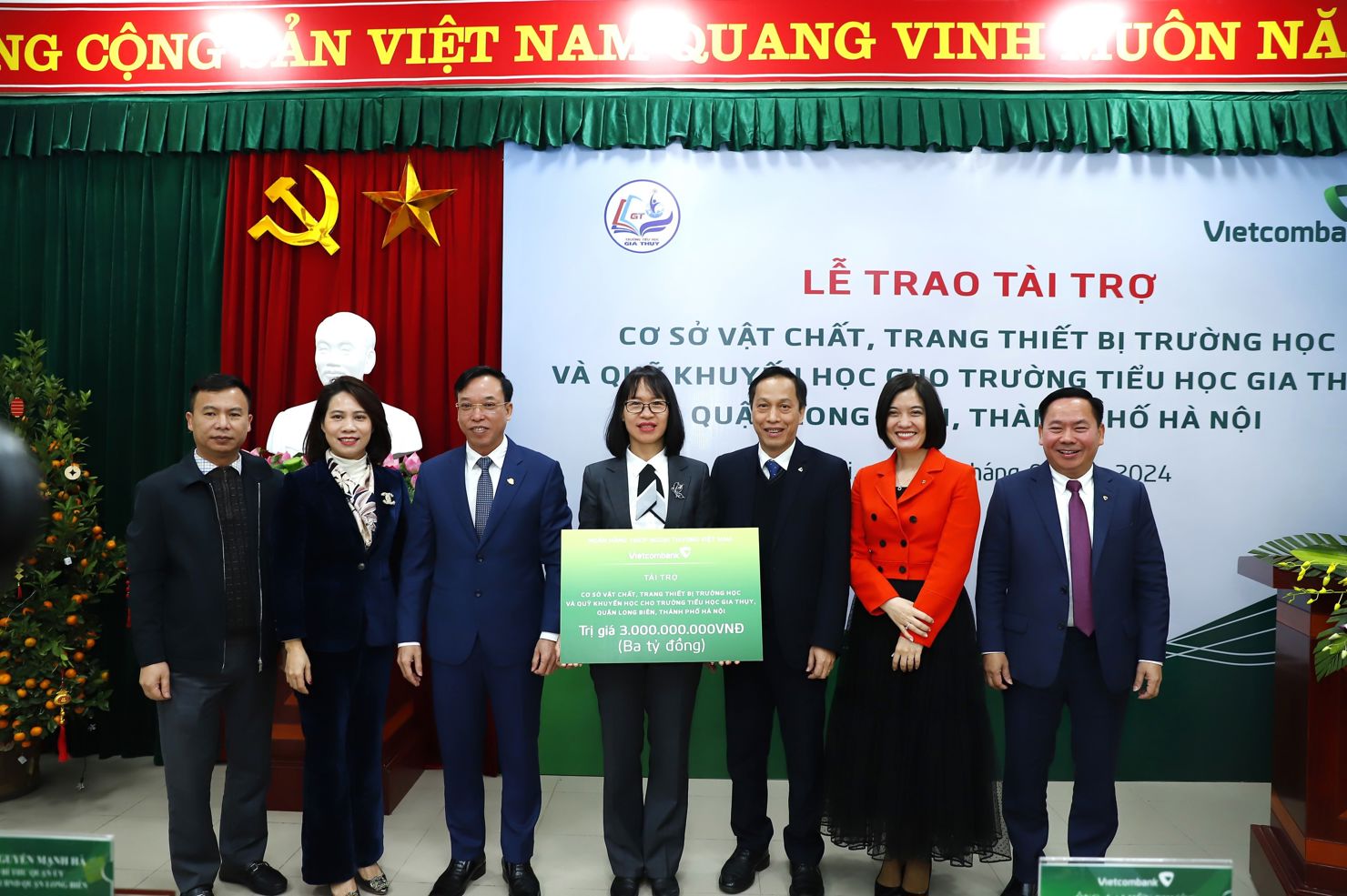 Ông Nguyễn Bá Minh - Giám đốc Vietcombank Chương Dương trao biển tượng trưng số tiền tài trợ ASXH cho cô giáo Bùi Thị Thu Hằng - Hiệu trưởng Trường Tiểu học Gia Thụy