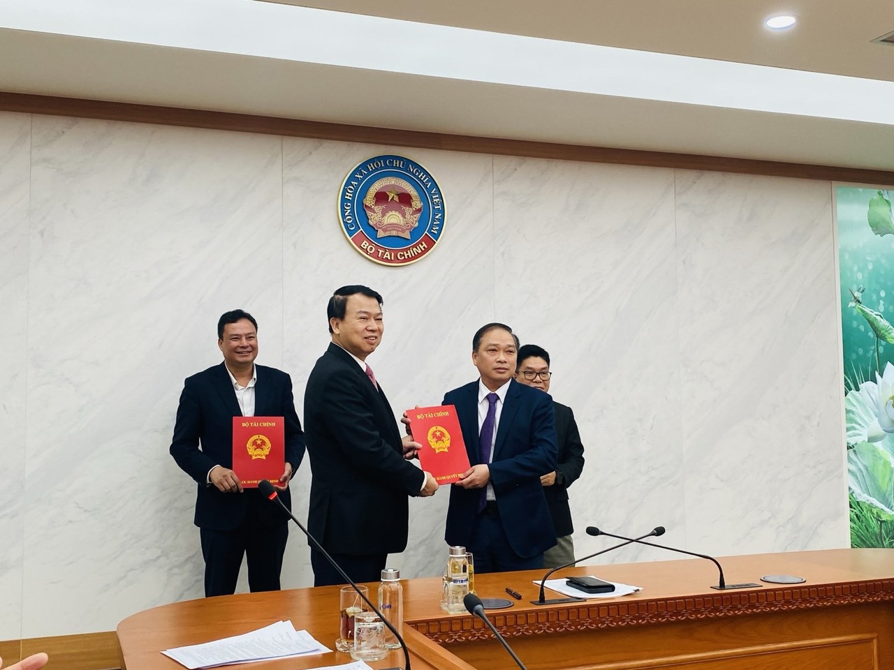 Thứ trưởng Bộ Tài chính Nguyễn Đức Chi trao Quyết định điều động và bổ nhiệm cho ông Lương Hải Sinh.