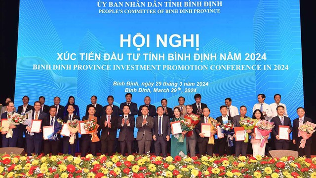 Lãnh đạo tỉnh Bình Định trao quyết định chủ trương đầu tư, giấy chứng nhận đăng ký đầu tư cho 22 dự án với tổng vốn đầu tư 12.713,5 tỷ đồng - Ảnh: VGP/Hải Minh