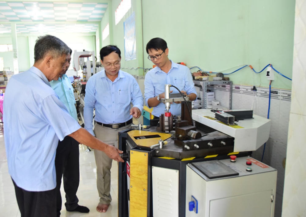 Ông Huỳnh Ngọc Xuân (thứ 2 từ phải sang) - Giám đốc Trung tâm khuyến công và Xúc tiến Thương mại tỉnh Trà Vinh nghiệm thu máy ép góc nhôm CNC.