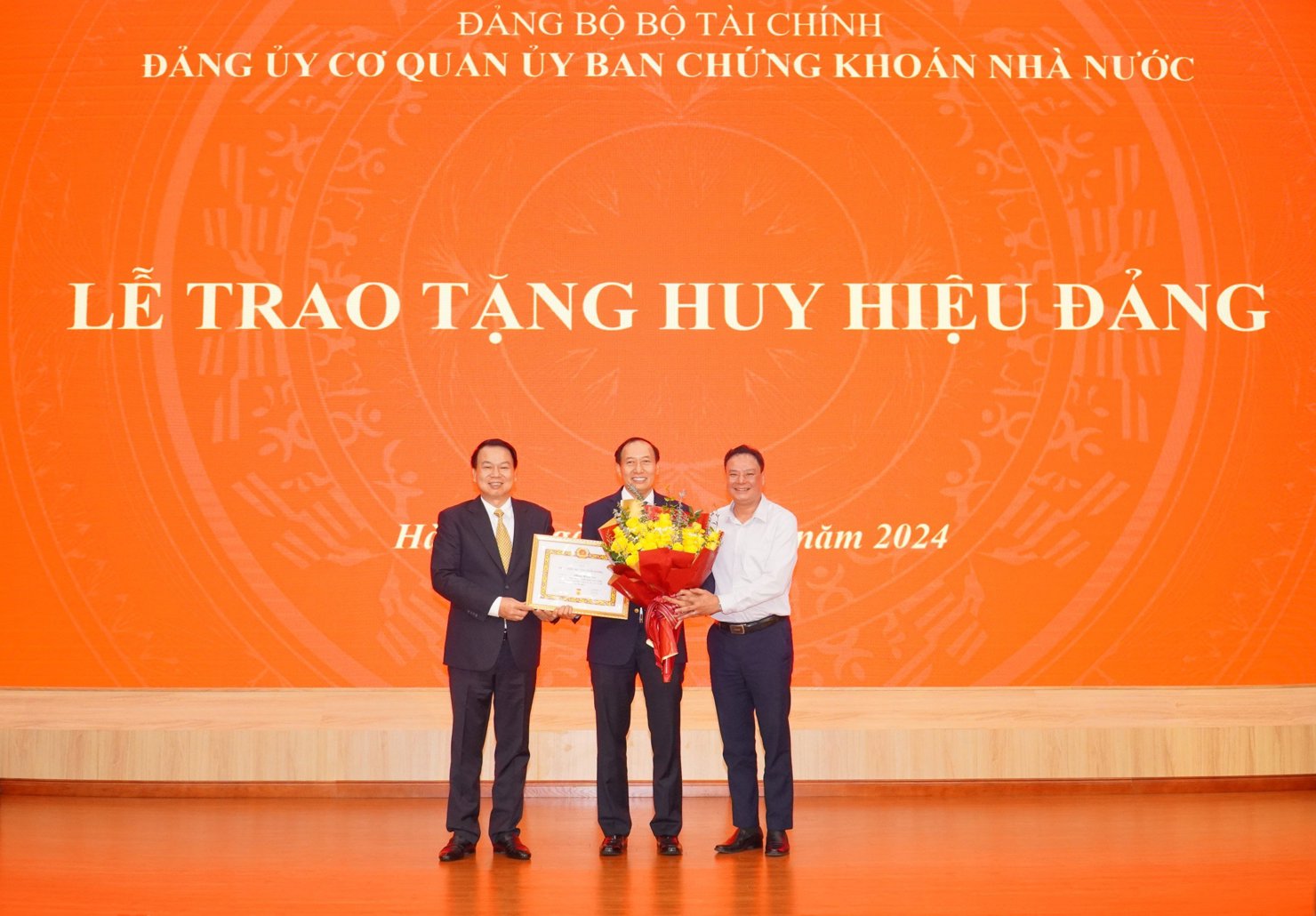 Thứ trưởng Nguyễn Đức Chi và Phó Bí thư thường trực Đảng ủy Bộ Tài chính Đỗ Văn Trường trao tặng Huy hiệu cho ông Phạm Hồng Sơn.