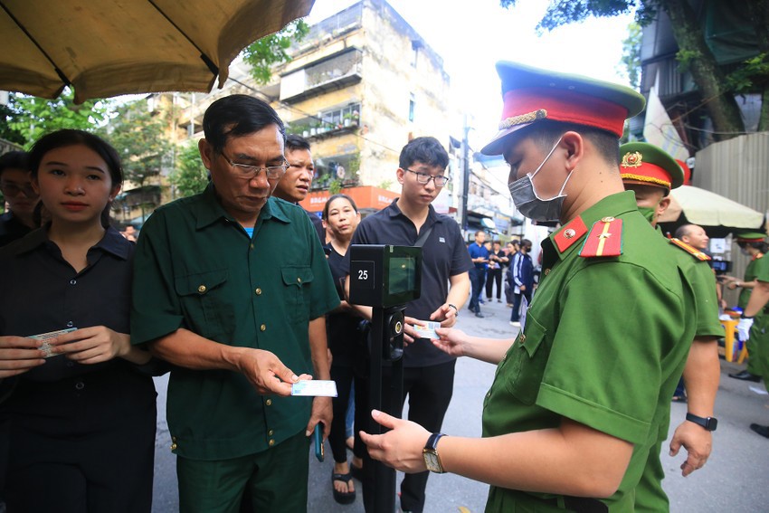 Đúng 18 giờ, nhiều người dân đã dùng thẻ căn cước để qua khu vực kiểm soát an ninh, vào nhà tang lễ viếng Tổng Bí thư Nguyễn Phú Trọng.