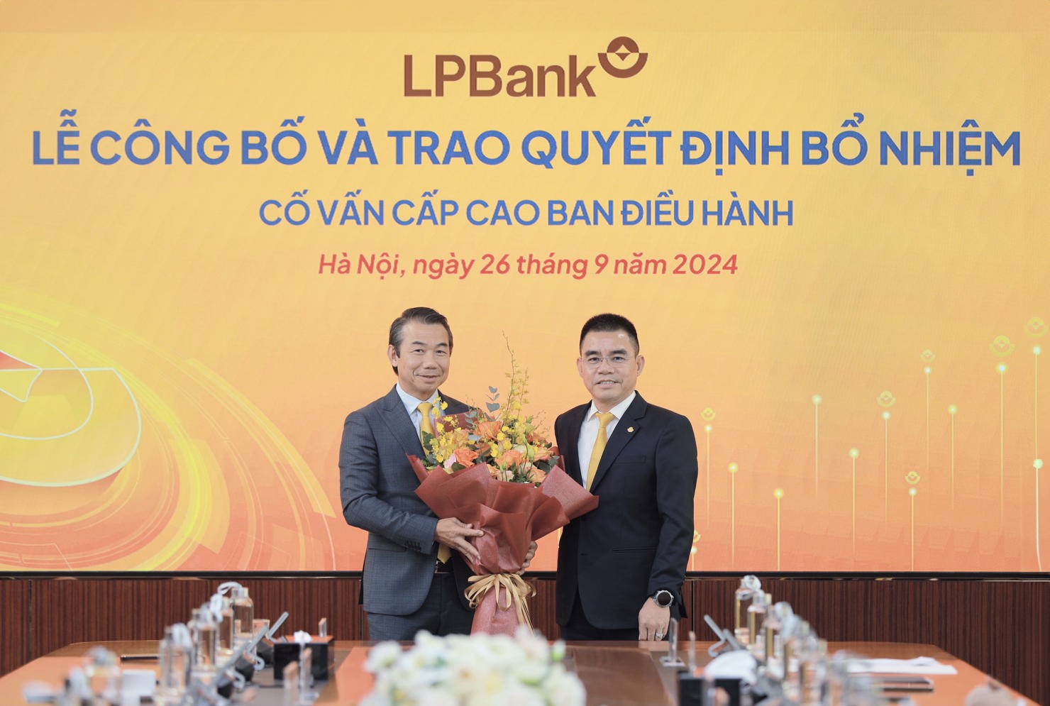 Ông Hồ Nam Tiến – Phó Chủ tịch HĐQT kiêm Tổng Giám đốc LPBank (phải)  trao hoa chúc mừng ông Phạm Phú Khôi (trái)