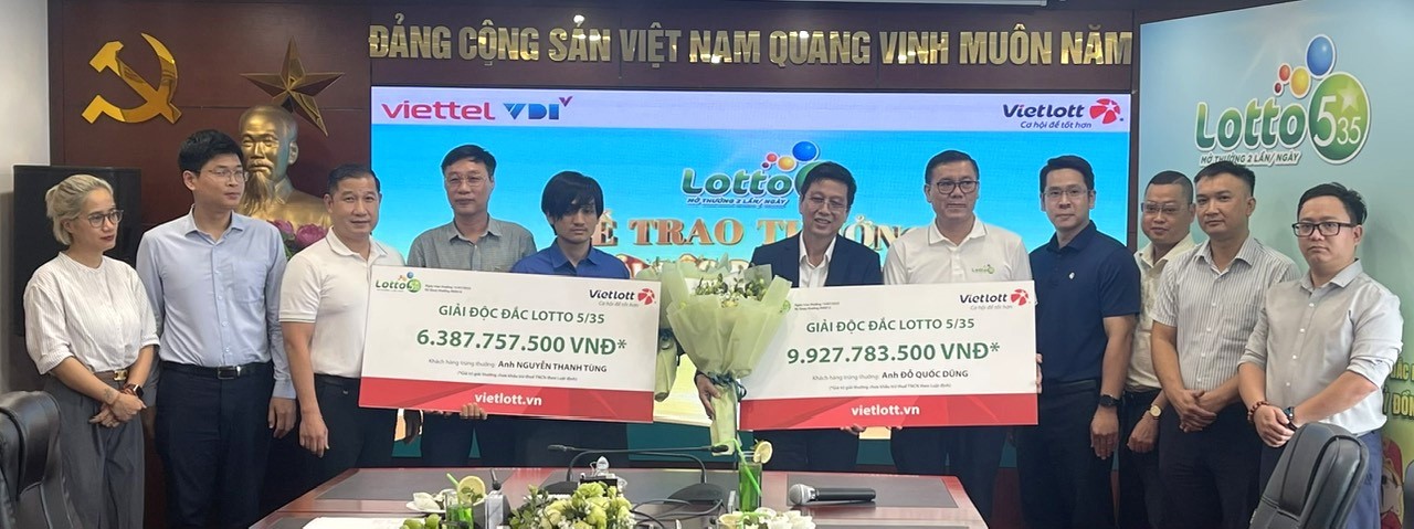 Anh Nguyễn Thanh Tùng (áo xanh bên trái) và anh Đỗ Quốc Dũng (áo vest bên phải) nhận giải độc đắc xổ số tự chọn Lotto 5/35. Ảnh: Vietlott
