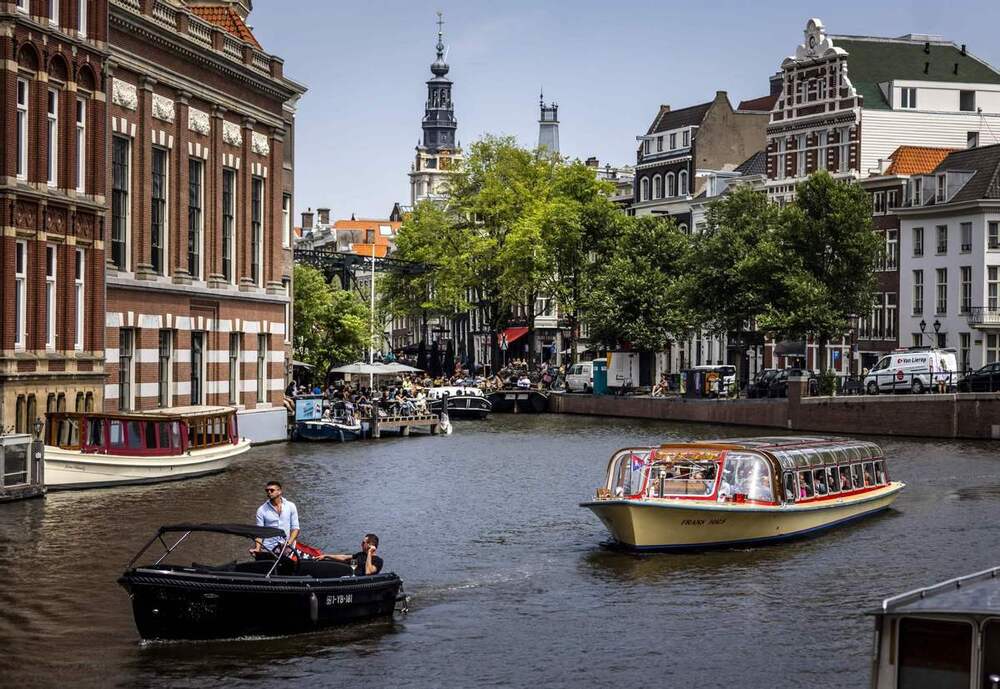 H&agrave;nh kh&aacute;ch đi du thuyền dọc theo một con k&ecirc;nh ở Amsterdam v&agrave;o ng&agrave;y 17/6/2022. Ảnh China Daily/Agencies