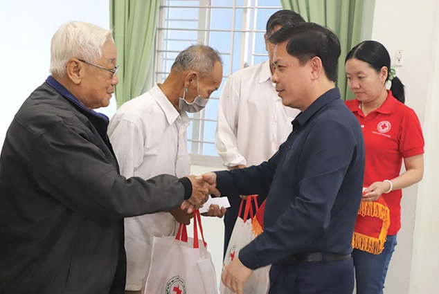 Ông Nguyễn Văn Thể - Ủy viên Ban Chấp hành Trung ương Đảng (bên phải) trao quà cho các gia đình chính sách. Ảnh: Mi Lê