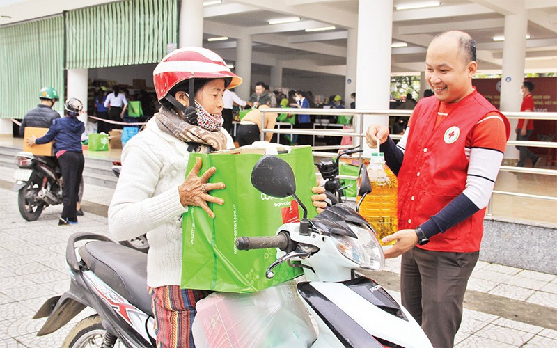 Hội viên Hội Chữ thập đỏ hỗ trợ người dân mua hàng ở Chợ Tết Nhân ái tại Ðà Nẵng. Ảnh : Thanh Tâm.