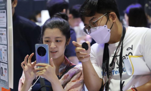 Một du khách kiểm tra điện thoại di động tại Mobile Expo 2023, Bangkok.