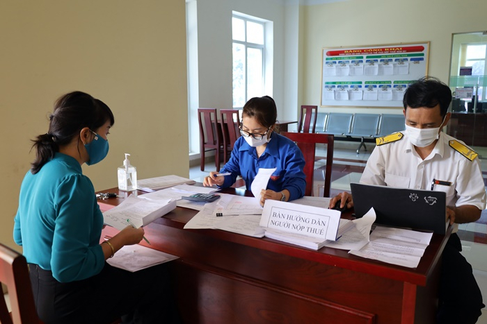 Cán bộ ngành thuế hướng dẫn, giải quyết thủ tục hành chính thuế cho người dân. Ảnh: Minh Chi