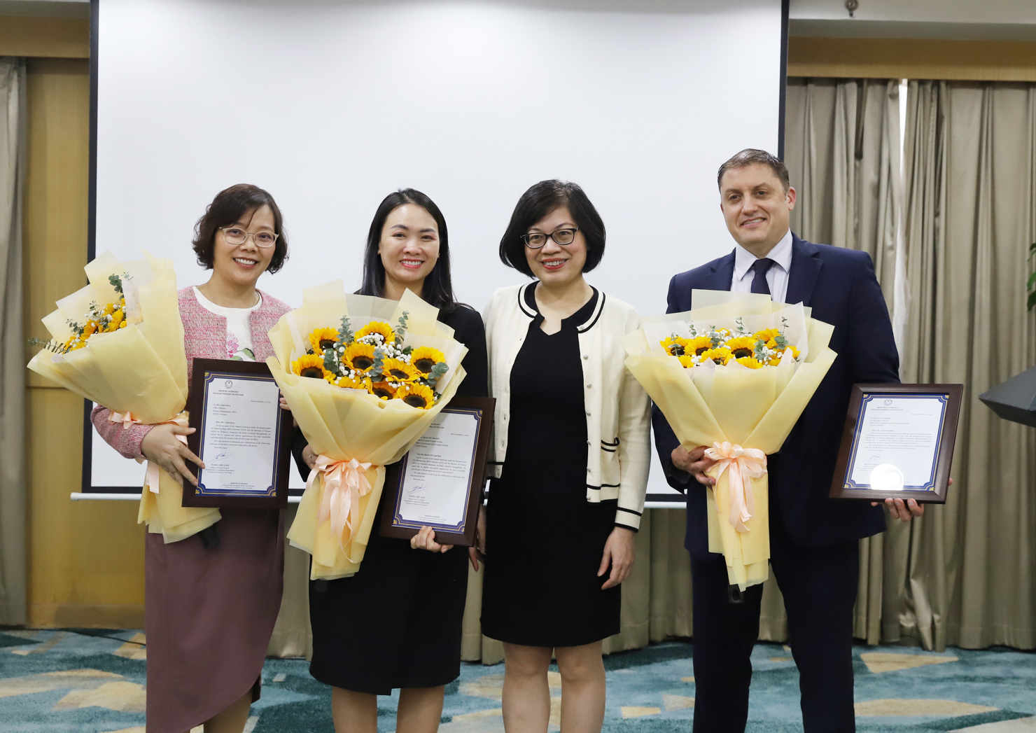 B&agrave; Ho&agrave;ng Diệu Linh trao thư cảm ơn của Bộ T&agrave;i ch&iacute;nh cho c&aacute;c đại diện của USAID.