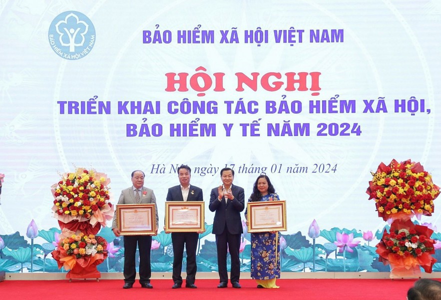 Ph&oacute; Thủ tướng Ch&iacute;nh phủ L&ecirc; Minh Kh&aacute;i trao Hu&acirc;n chương Lao động hạng Ba v&agrave; danh hiệu Chiến sĩ thi đua to&agrave;n quốc cho c&aacute;c c&aacute; nh&acirc;n của BHXH Việt Nam.