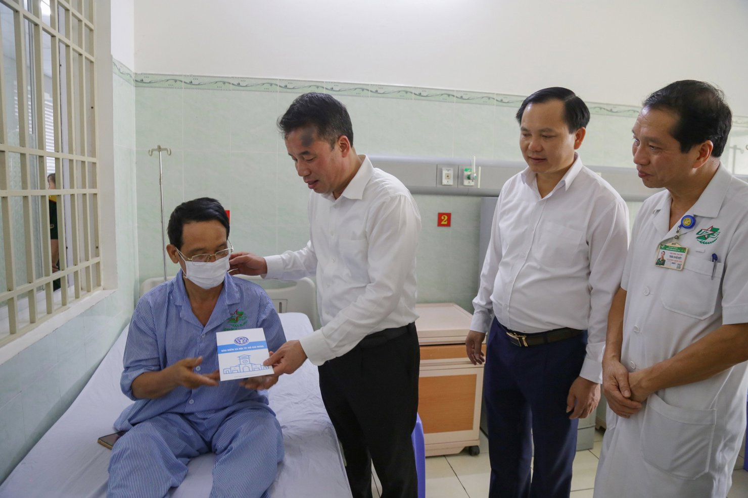 Tổng Gi&aacute;m đốc BHXH Việt Nam Nguyễn Thế Mạnh tặng sổ BHYT cho bệnh nh&acirc;n ngh&egrave;o đang điều trị tại Bệnh vi&ecirc;n Qu&acirc;n y 105.