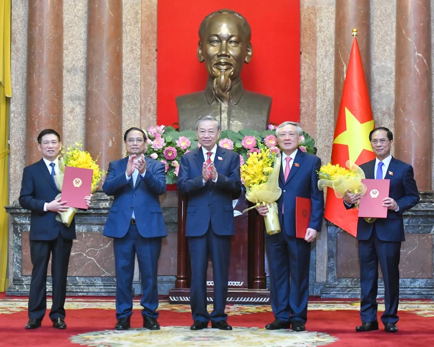 Tổng Bí thư, Chủ tịch nước Tô Lâm trao Quyết định bổ nhiệm, Thủ tướng Phạm Minh Chính tặng hoa chúc mừng các Phó Thủ tướng Nguyễn Hòa Bình, Hồ Đức Phớc và Bùi Thanh Sơn.