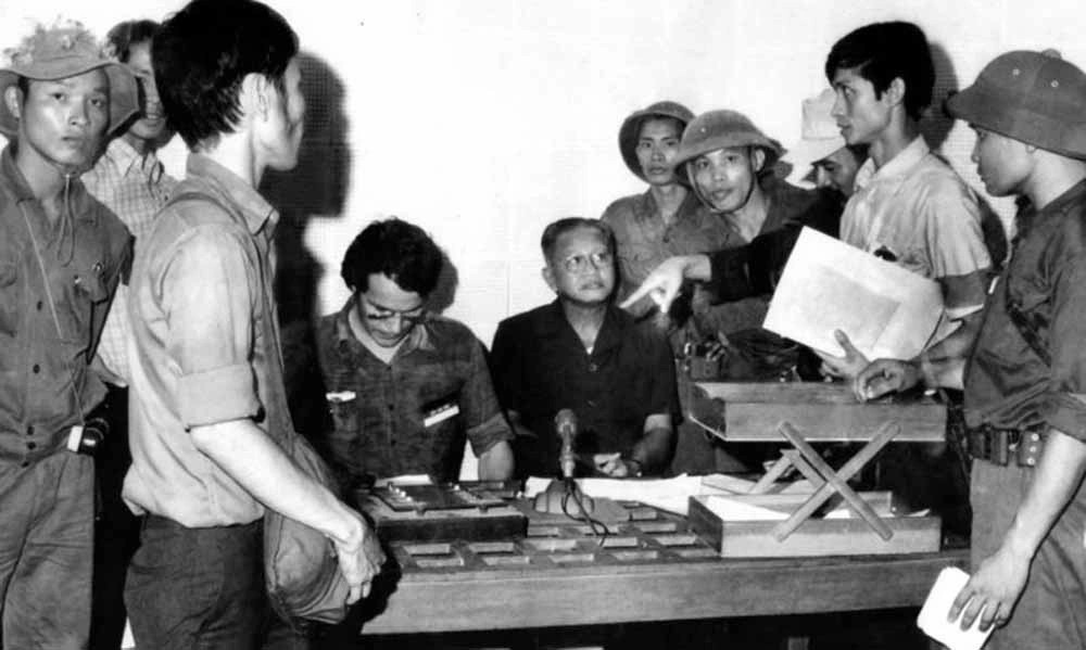 Ông Dương Văn Minh (áo đen, ngồi) đọc lời tuyên bố đầu hàng vô điều kiện.