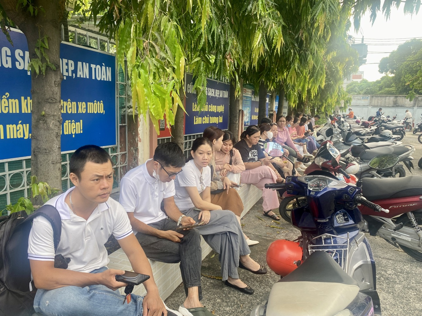 Phụ huynh chờ con tại điểm thi trường THCS Bình Thọ.