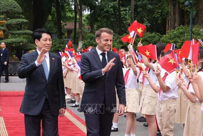 Chủ tịch nước Lương Cường v&agrave; Tổng thống Ph&aacute;p Emmanuel Macron với thiếu nhi Thủ đ&ocirc; H&agrave; Nội. Ảnh: TTXVN