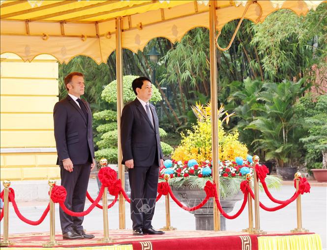 Chủ tịch nước Lương Cường v&agrave; Tổng thống Ph&aacute;p Emmanuel Macron nghe qu&acirc;n nhạc cử Quốc thiều hai nước. Ảnh: TTXVN