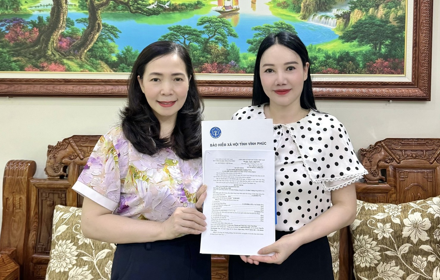 Cán bộ Bảo hiểm xã hội trao Quyết định hưởng lương hưu cho bà Yên.