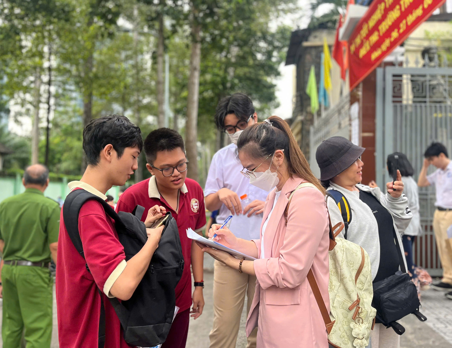 Thí sinh tranh thủ dò bài cùng giáo viên trước khi thi môn ngữ văn. Ảnh: T.D
