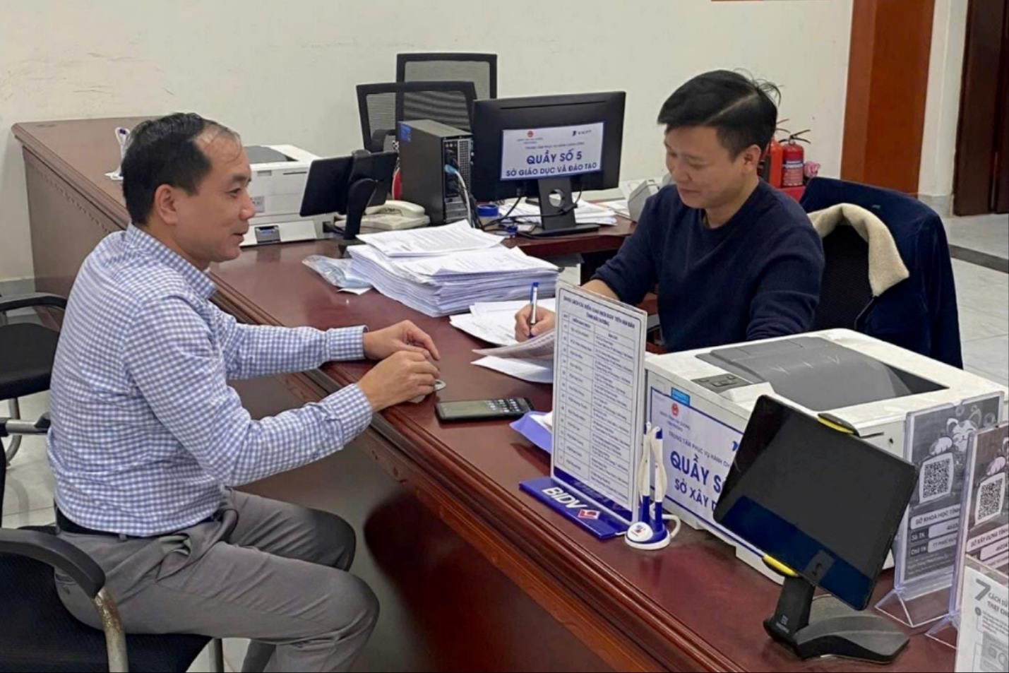 Cán bộ Sở Xây dựng hướng dẫn người dân thủ tục hành chính.