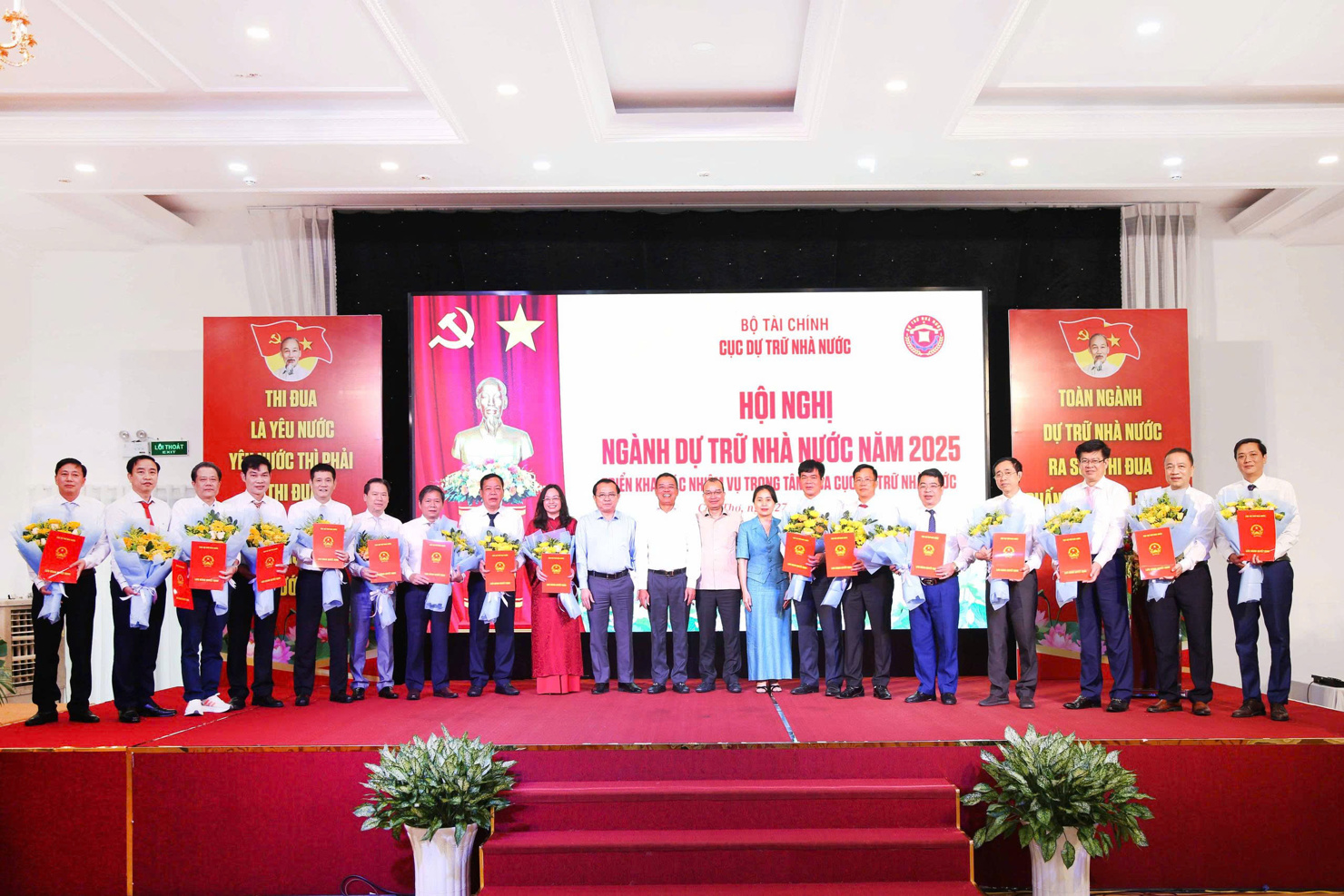 Thứ trưởng Bộ Tài chính Lê Tấn Cận tặng hoa chúc mừng những cán bộ được bổ nhiệm. 