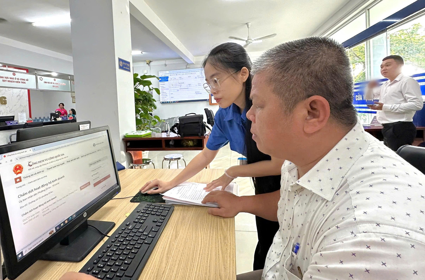 T&igrave;nh nguyện vi&ecirc;n hỗ trợ người d&acirc;n thực hiện thủ tục h&agrave;nh ch&iacute;nh tại&nbsp;Trung t&acirc;m Phục vụ h&agrave;nh ch&iacute;nh c&ocirc;ng phường Dĩ An trong ng&agrave;y 1/7/2025. Ảnh: Phạm Thọ
