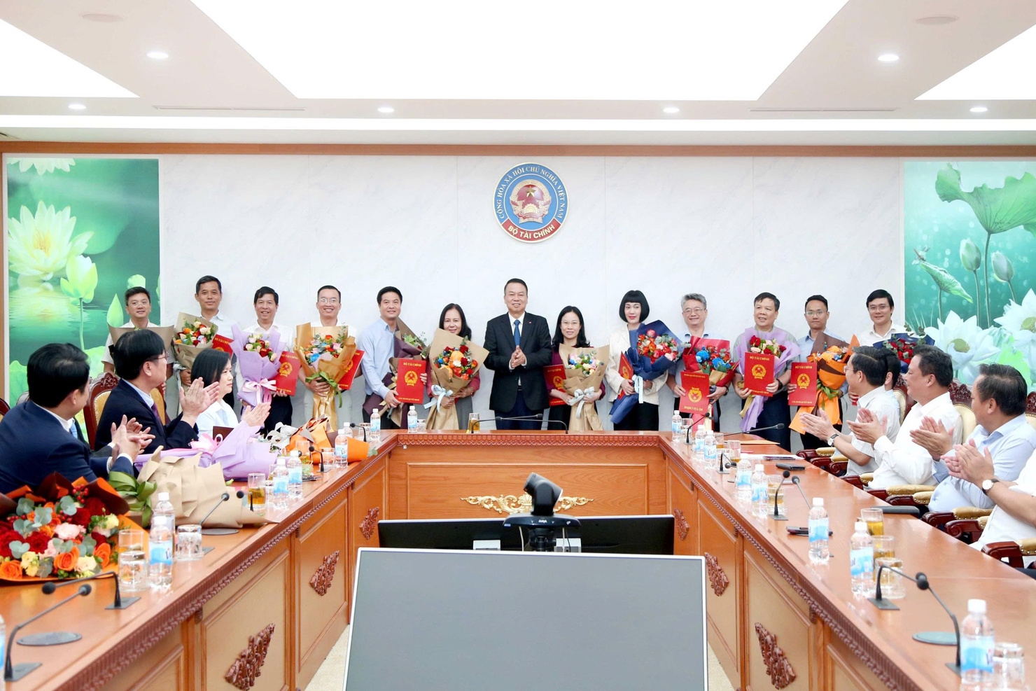 Thứ trưởng Nguyễn Đức Chi trao quyết định điều động, bổ nhiệm và tặng hoa cho 12 tân phó Vụ trưởng các vụ thuộc Bộ Tài chính. 