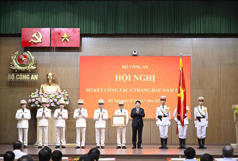 Chủ tịch nước Lương Cường gắn Huân chương lên lá Cờ truyền thống và trao Bằng Huân chương Lao động hạng Ba tặng Bộ Công an.