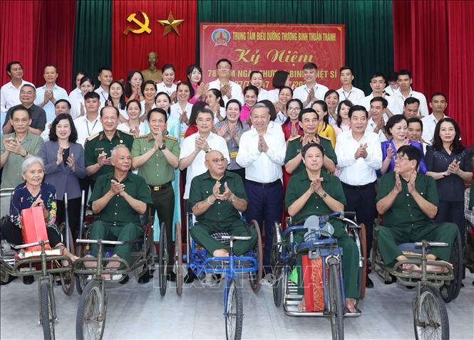 Tổng Bí thư Tô Lâm và các đại biểu chụp ảnh cùng thương bệnh binh và cán bộ, nhân viên Trung tâm Điều dưỡng thương binh Thuận Thành. Ảnh: Thống Nhất/TTXVN. 