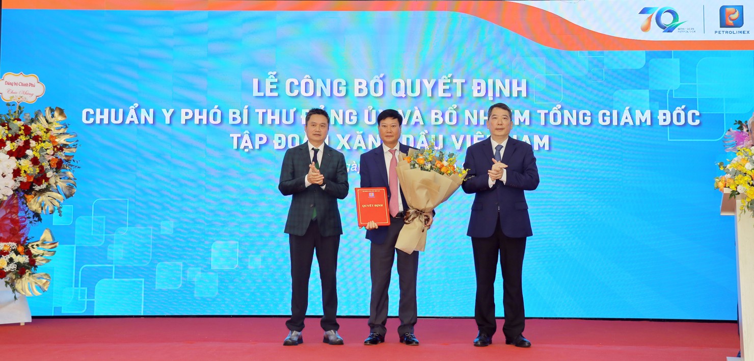 Thứ trưởng Bộ Tài Chính Cao Anh Tuấn (phải) và ông Phạm Văn Thanh (trái) trao Quyết định bổ nhiệm và tặng hoa chúc mừng tân Tổng Giám đốc Petrolimex Lưu Văn Tuyển.