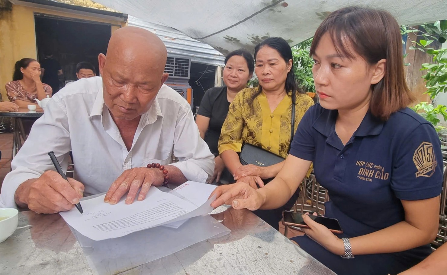 Nhân viên Prudential hướng dẫn khách hàng tham gia bảo hiểm là nạn nhân vụ lật tàu làm các thủ tục để nhận bồi thường bảo hiểm. Ảnh: Nguyễn Thanh