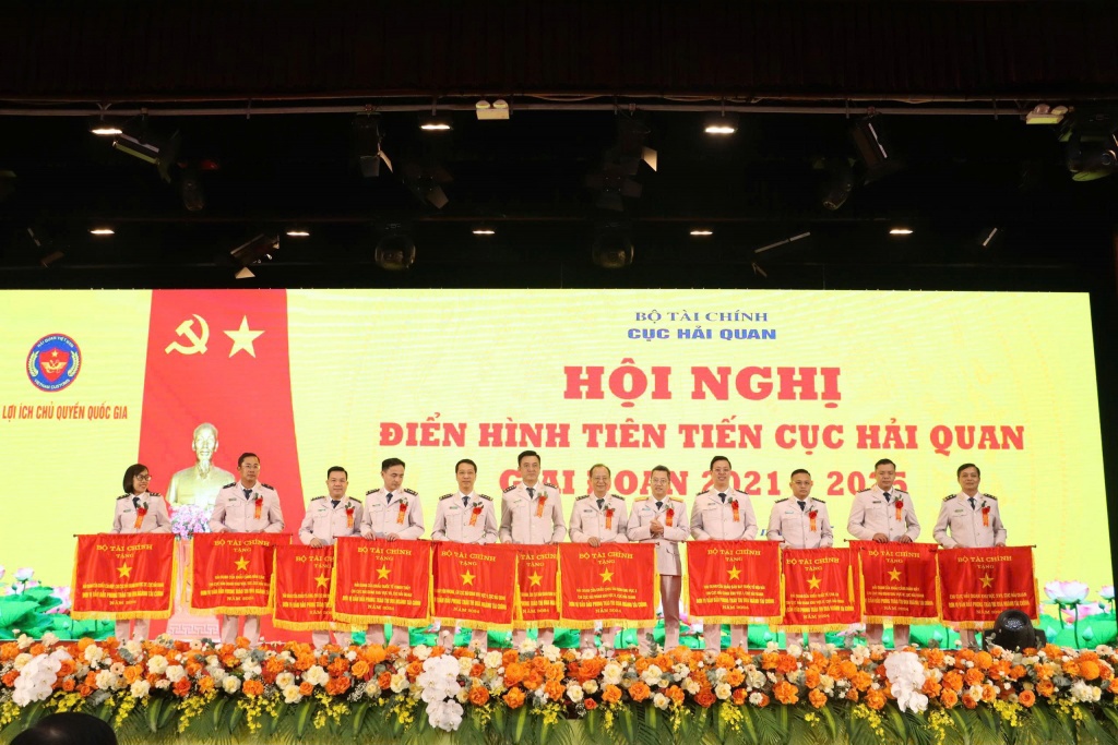 Ph&oacute; Cục trưởng Cục Hải quan &Acirc;u Anh Tuấn (thứ 5 b&ecirc;n phải qua) thừa ủy quyền trao Cờ thi đua của Bộ T&agrave;i ch&iacute;nh tặng 11 tập thể c&oacute; th&agrave;nh t&iacute;ch xuất sắc. Ảnh: Quang H&ugrave;ng.