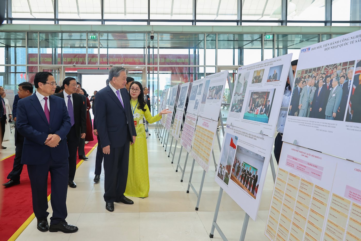 Tổng B&iacute; thư T&ocirc; L&acirc;m v&agrave; Thủ tướng Phạm Minh Ch&iacute;nh c&ugrave;ng c&aacute;c đại biểu tham quan trưng b&agrave;y ảnh về hoạt động của Ch&iacute;nh phủ qua c&aacute;c thời kỳ. Ảnh: VGP/Nhật Bắc